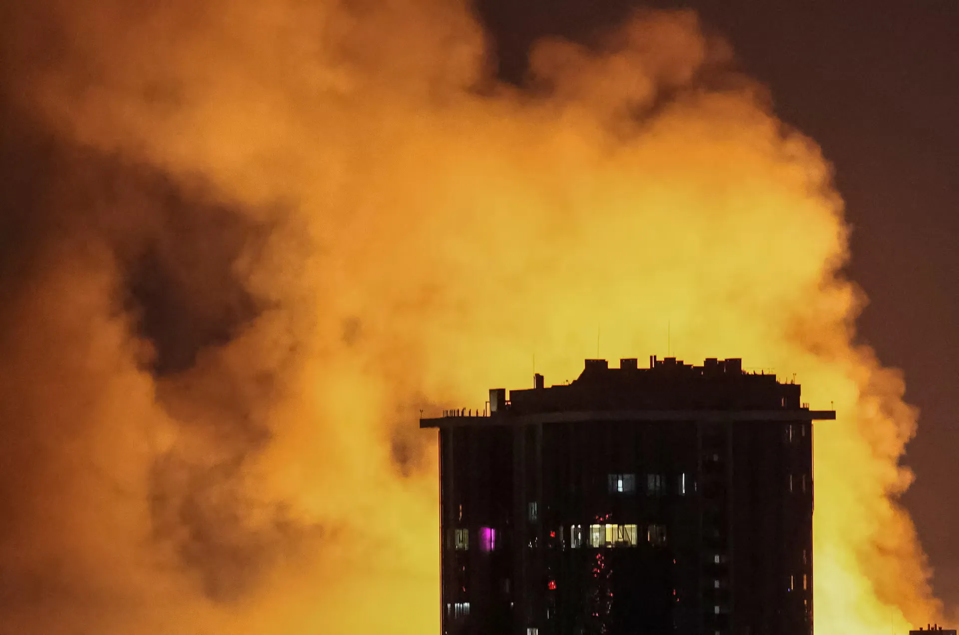 Вибух безпілотника освітлює небо над містом під час російського удару безпілотника та ракети на тлі нападу Росії на Україну, у Києві, Україна, 4 липня 2025 року